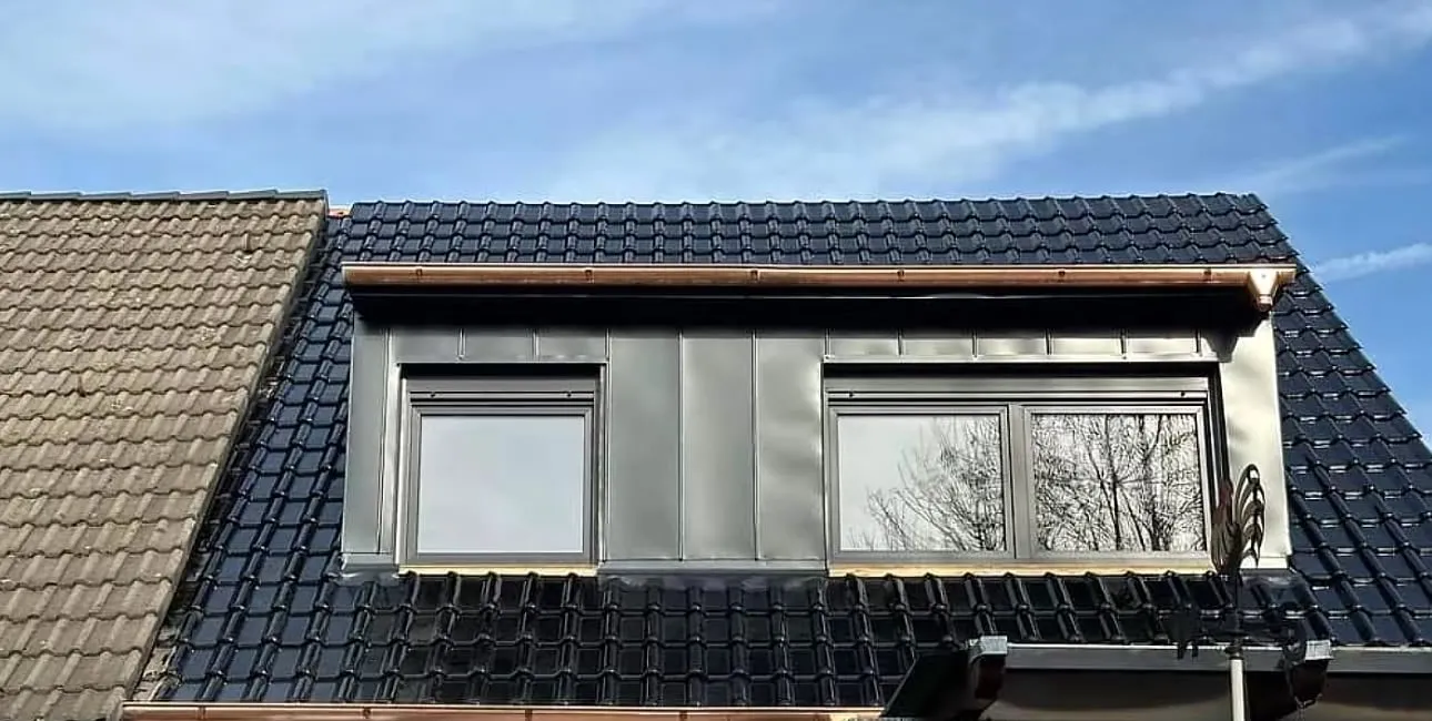 Fertig sanierte Dachfläche mit neuer Gaube, glasierten Tondachziegeln und Kupferdachrinnen